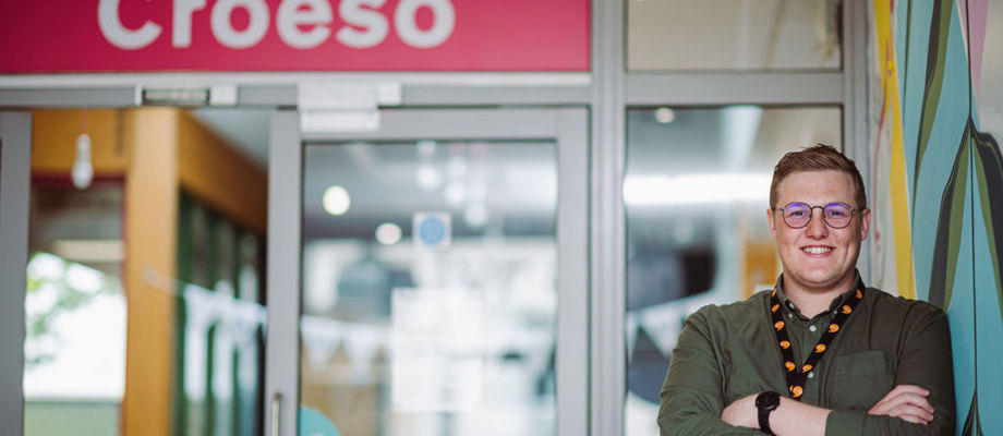 Man standing next to croeso sign