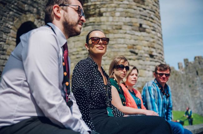 image of five people sitting by a castle